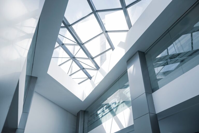 Commercial interior an interior look at a modern office building featuring a glass ceiling and sleek steel frames