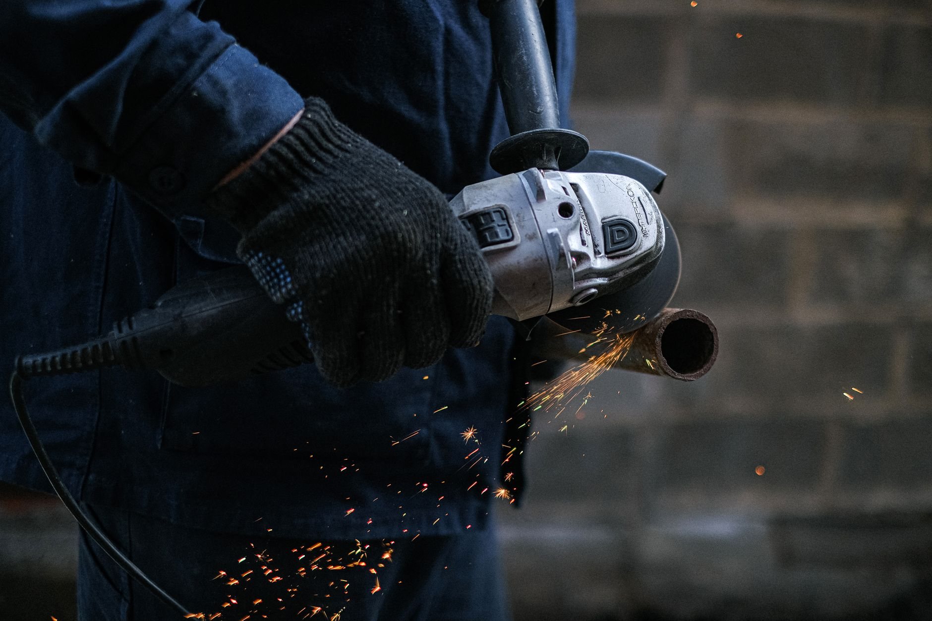 Grinding a welded steel joint smooth before finish coating on a gate frame