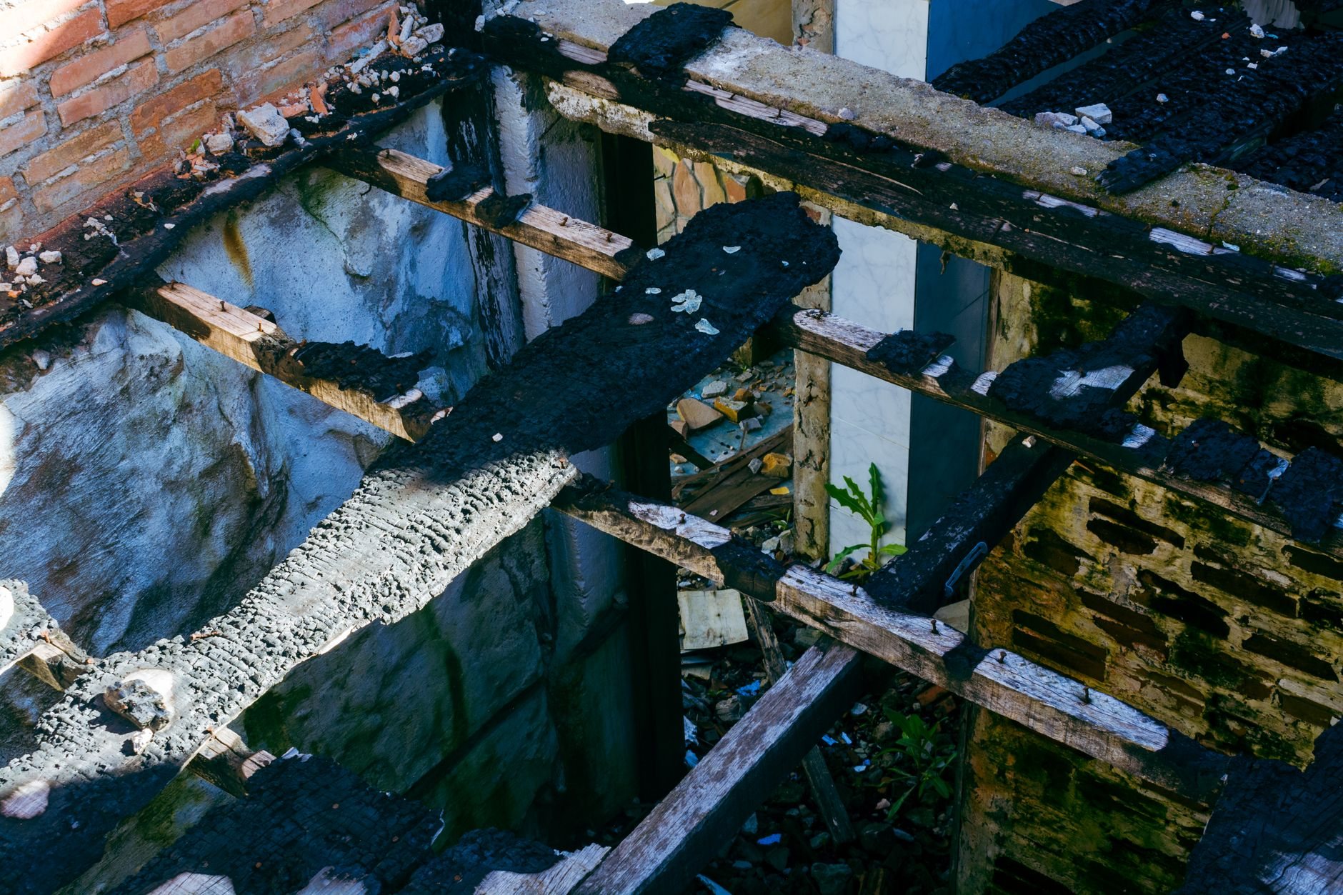 Fire-damaged structure stripped to charred framing before reconstruction begins