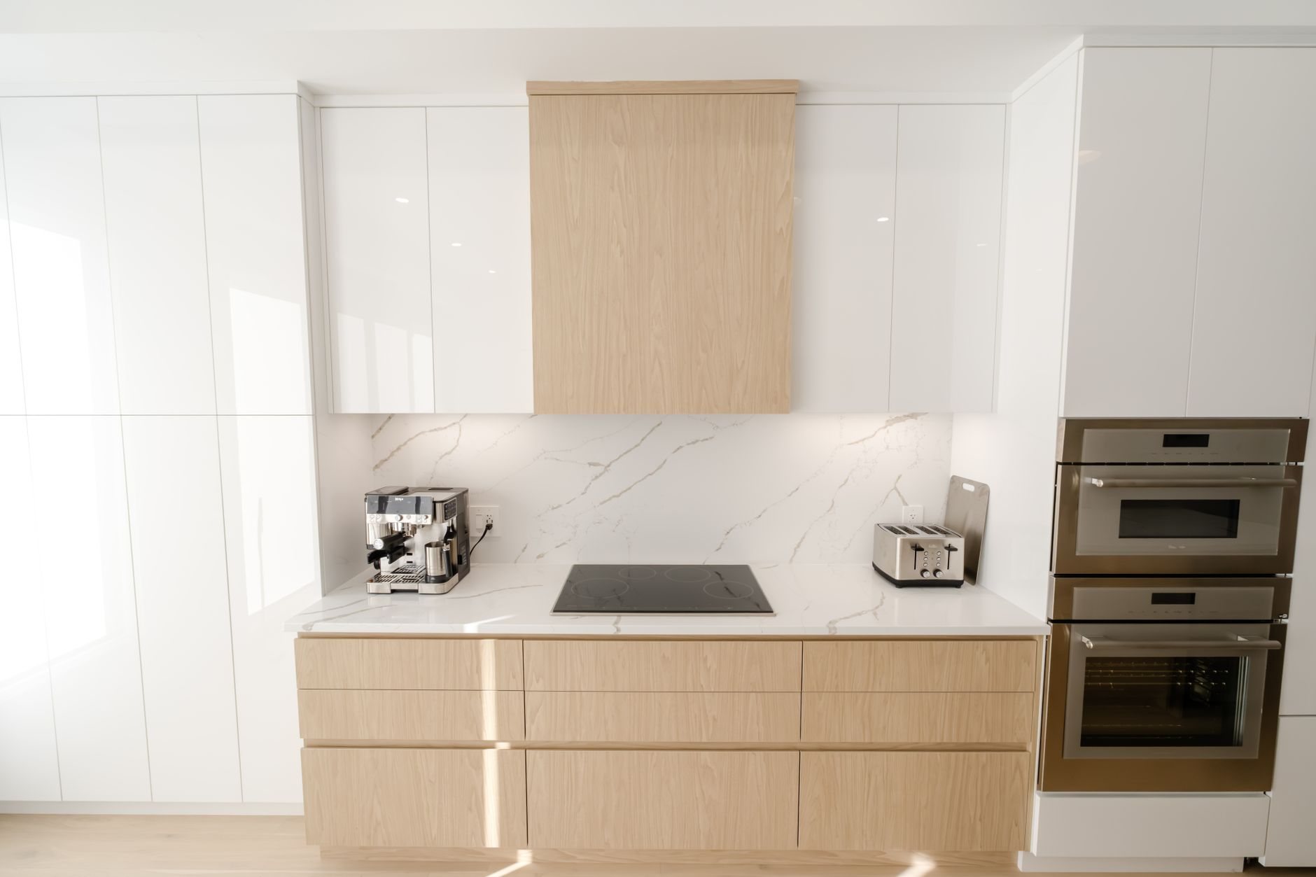 Contemporary kitchen with flat-panel cabinetry and built-in appliances in a modern custom home