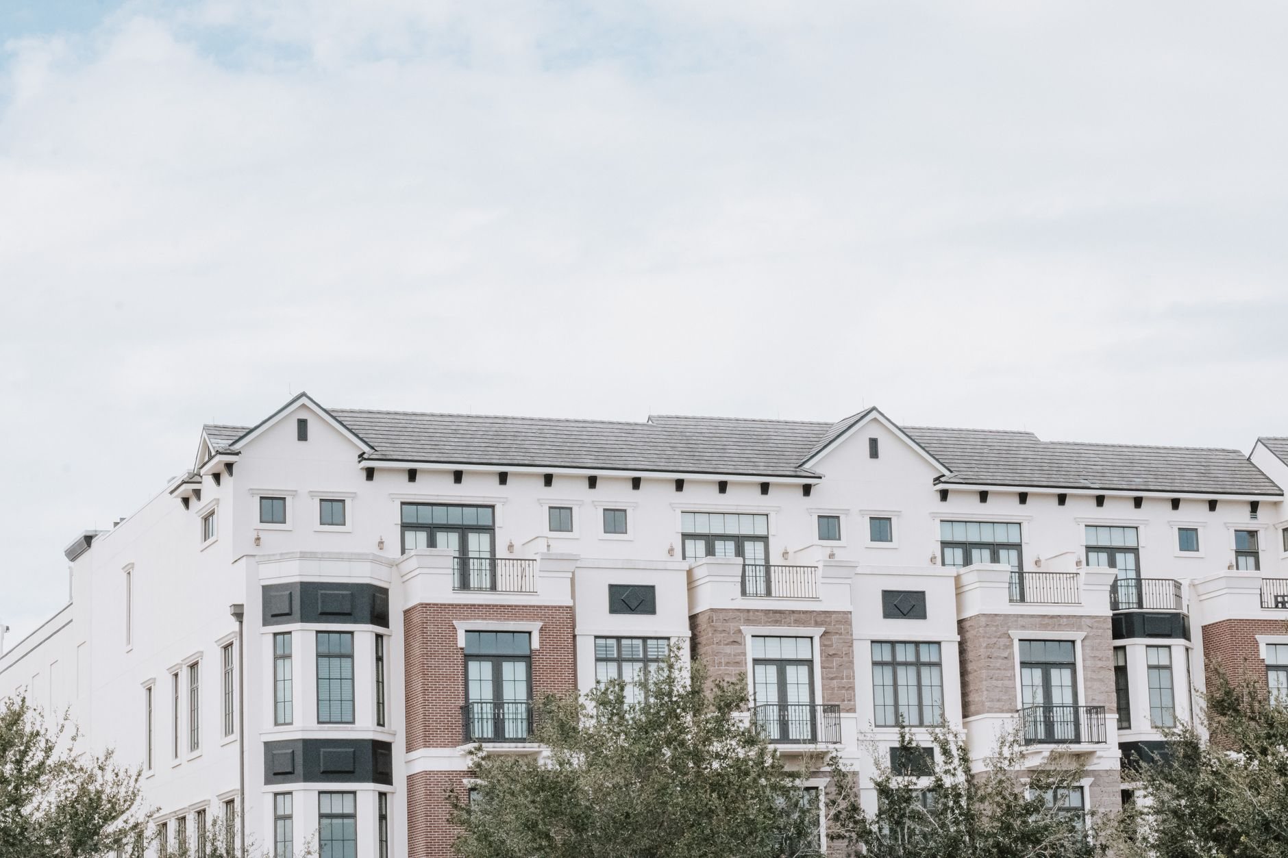 Multifamily property a stylish, multi-story luxury apartment building with a contemporary facade against a clear sky