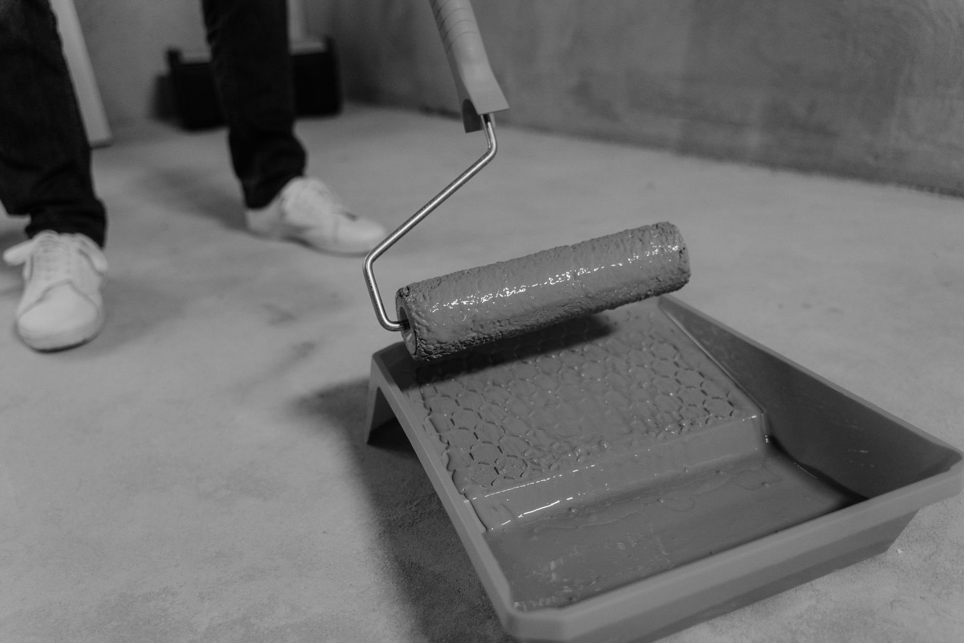 Close-up of a paint roller and tray during a patch repaint