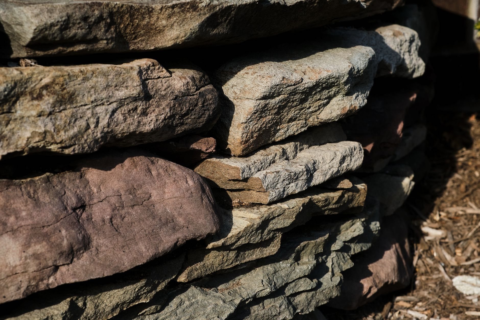 Stone retaining wall holding back a terraced slope, the kind of grade change common on Bluffdale bench lots