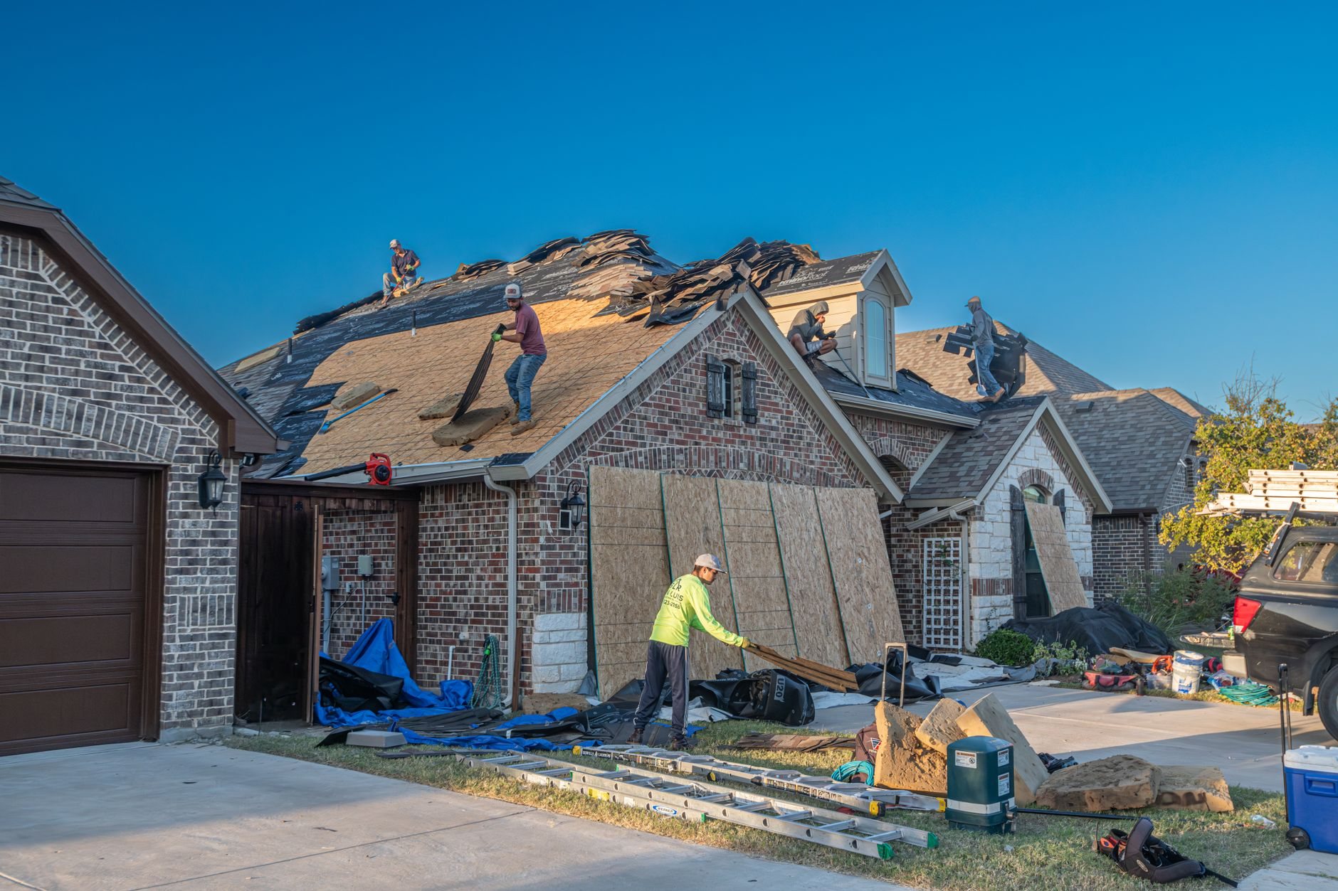 Crew working on a roof replacement, the stage when gutter replacement is most economical