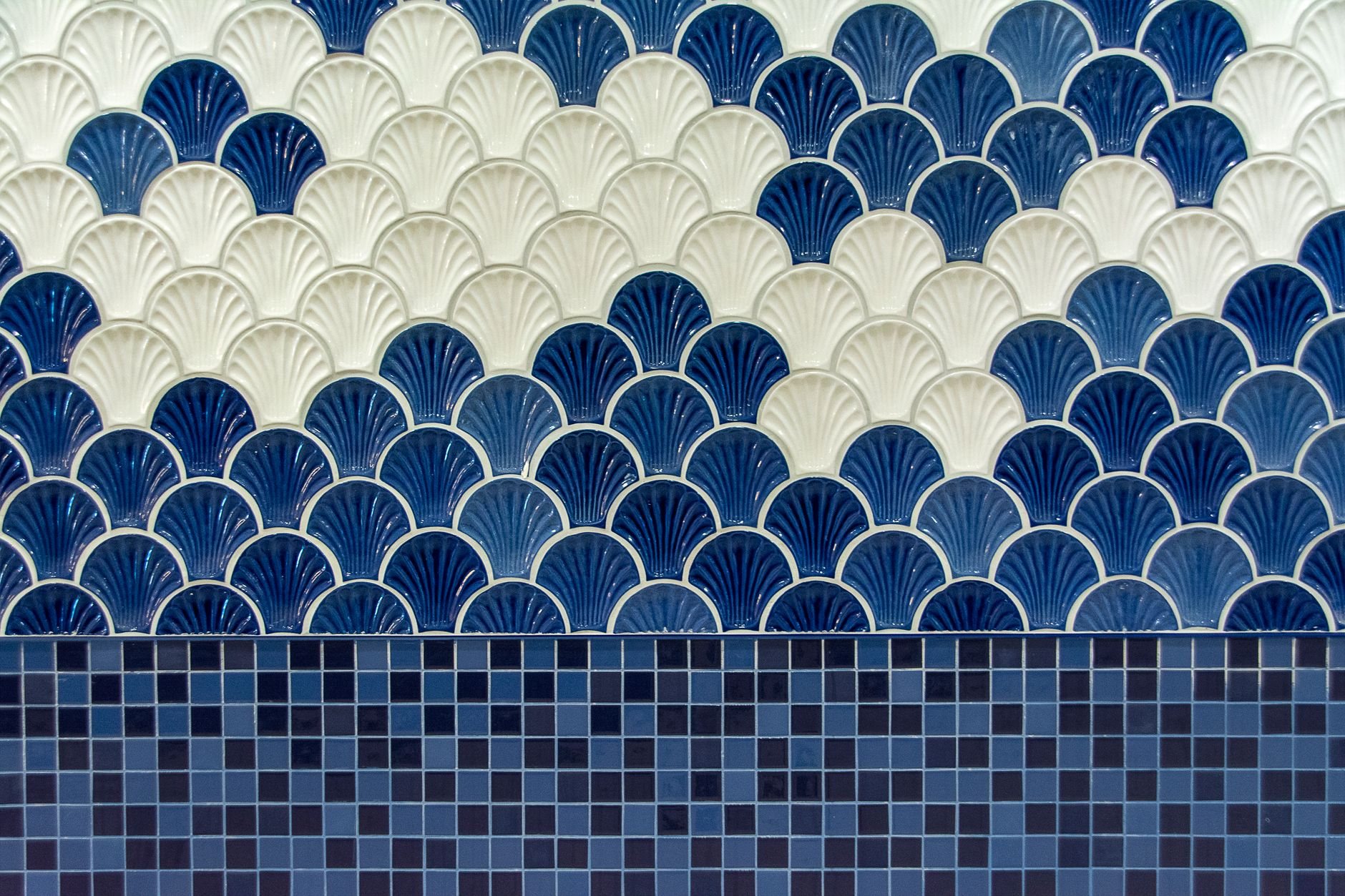 Blue and white scallop-pattern mosaic tile installed on a feature wall