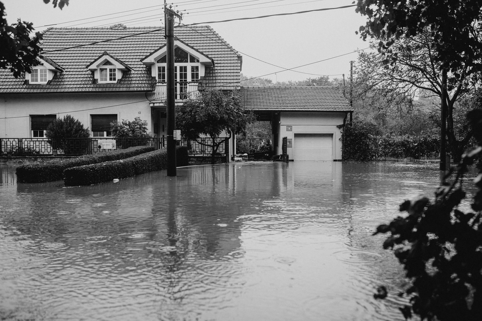 Home surrounded by standing water after heavy rain, the kind of storm runoff Utah drainage systems are built to handle