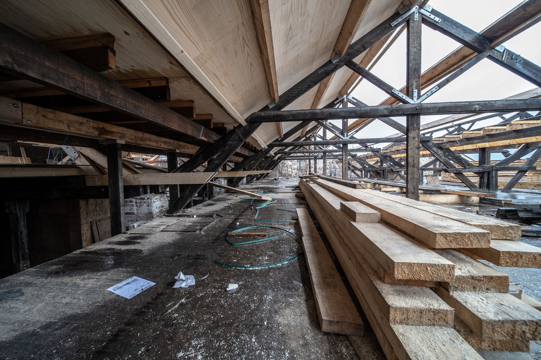 Exposed wood beams in an attic loft during conversion framing