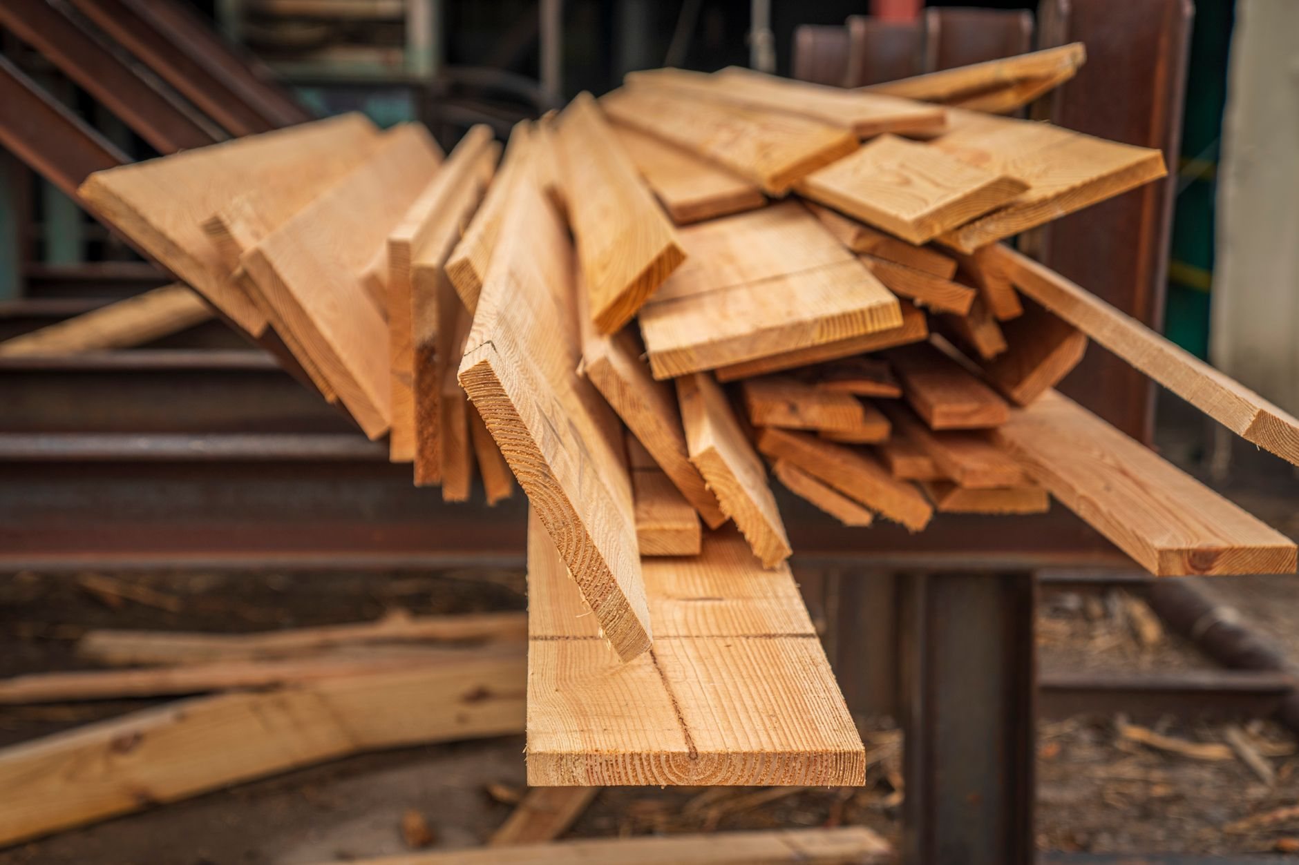 Stacked dimensional lumber staged for framing, a common target of material substitution pricing